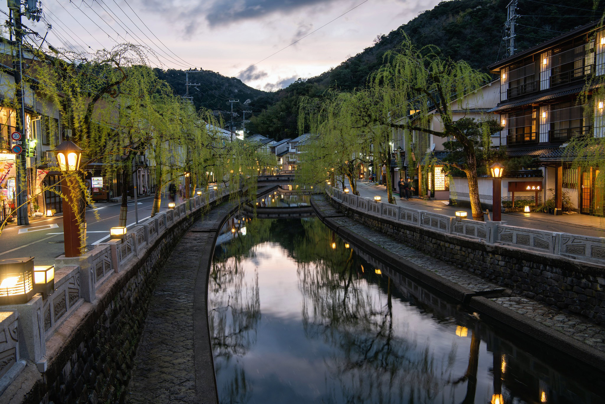 evening walk over the stone bridges in Kinosaki along the canal lined with weeping willows